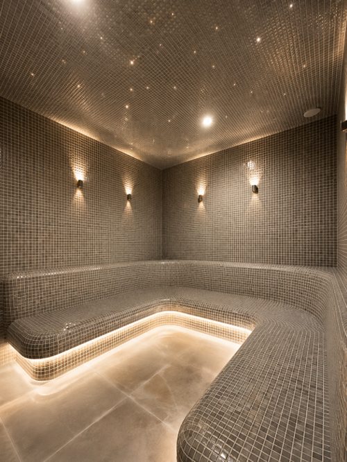 Mosaic steam room with starlit ceiling and bench seating